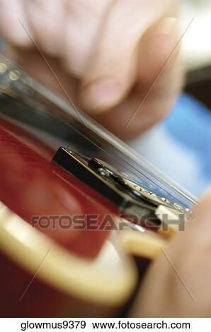 Extreme close-up of man playing electric guitar View Large Photo Image Stock Photo - Extreme close-up of man playing electric guitar. Fotosearch