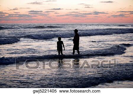 Father and his daughter standing in the water at the beach View Large Photo Image Stock Photography - Father and his daughter standing in the water at the beach. Fotosearch