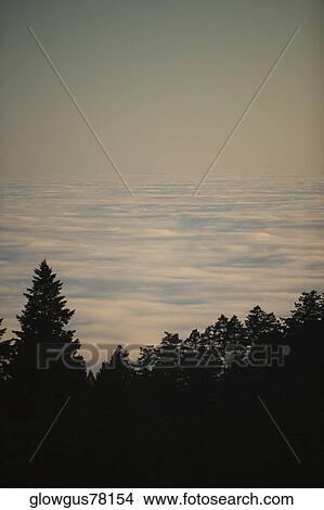 High angle view of a hill surrounded by clouds View Large Photo Image Picture - High angle view of a hill surrounded by clouds. Fotosearch