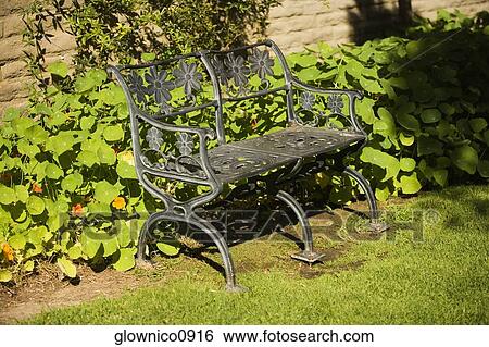 Stock Photograph - High angle view of an iron bench in a garden. Fotosearch