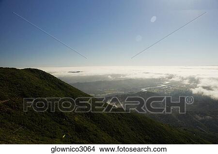 High angle view of clouds around a hill range View Large Photo Image Picture - High angle view of clouds around a hill range. Fotosearch