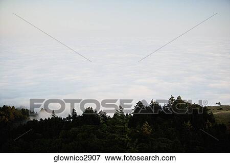 High angle view of clouds around a hill View Large Photo Image Stock Photo - High angle view of clouds around a hill. Fotosearch
