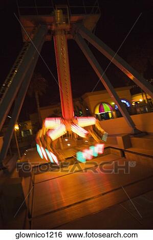 Stock Photograph - Lights glowing on a carnival ride at night, California, USA. Fotosearch