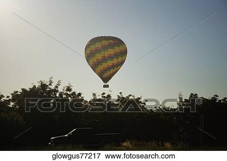 Stock Photo - Low angle view of a hot air balloon flying in the sky. Fotosearch