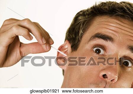 Stock Image - Man using cotton swab in ear. Fotosearch