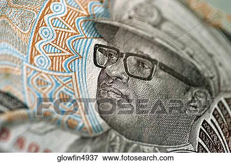 Stock Photo -  man wearing glasses on bank note, extreme close-up. Fotosearch