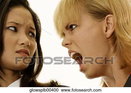 Stock Image - One woman yelling at another woman. Fotosearch