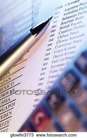 Stock Image - Pen in front of list of world currencies with codes for each country, close-up, full frame. Fotosearch