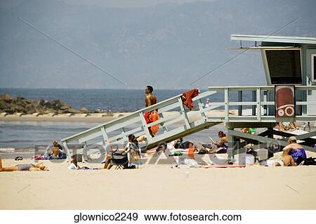 People sitting around a lifeguard stand on the beach View Large Photo Image Stock Photo - People sitting around a lifeguard stand on the beach. Fotosearch