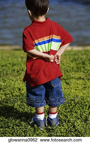 Rear view of a boy standing on a lawn View Large Photo Image Stock Image - Rear view of a boy standing on a lawn. Fotosearch