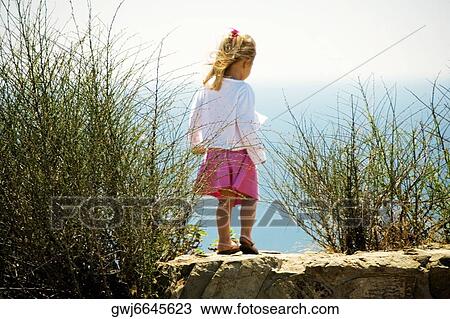 Stock Image - Rear view of a girl standing on the waterfront, San Diego, California, USA. Fotosearch