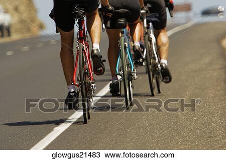 Rear view of a group of people cycling View Large Photo Image Stock Image - Rear view of a group of people cycling. Fotosearch