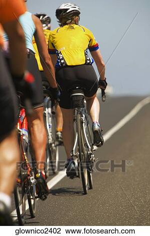 Rear view of a group of people cycling View Large Photo Image Stock Image - Rear view of a group of people cycling. Fotosearch
