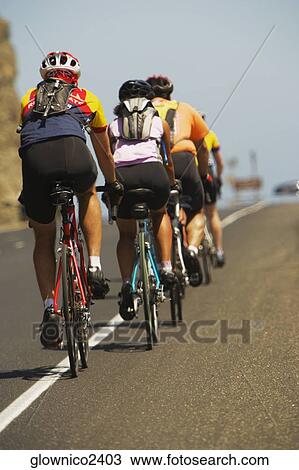 Rear view of a group of people cycling View Large Photo Image Stock Image - Rear view of a group of people cycling. Fotosearch