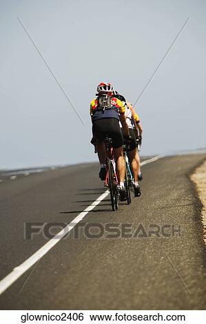 Rear view of a group of people cycling View Large Photo Image Stock Photograph - Rear view of a group of people cycling. Fotosearch