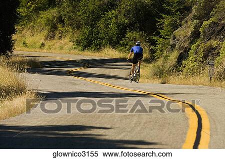 Rear view of a person cycling View Large Photo Image Stock Photography - Rear view of a person cycling. Fotosearch