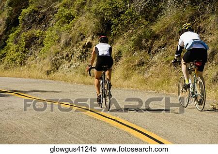 Stock Photography - Rear view of two people cycling. Fotosearch