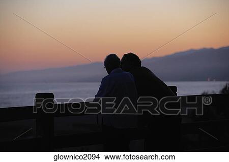 Rear view of two people standing on a pier View Large Photo Image Picture - Rear view of two people standing on a pier. Fotosearch