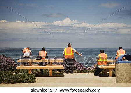 Rear view of workers looking at the ocean view View Large Photo Image Stock Photo - Rear view of workers looking at the ocean view. Fotosearch
