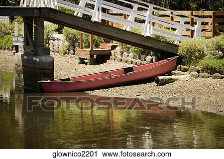 Rowboat under a bridge over a canal View Large Photo Image Stock Image - Rowboat under a bridge over a canal. Fotosearch