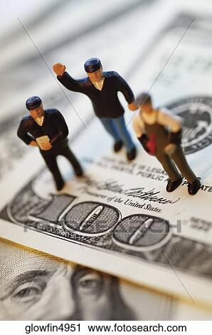 Three toy men standing on top of United States one hundred dollar bills, close-up View Large Photo Image Stock Image - Three toy men standing on top of United States one hundred dollar bills, close-up. Fotosearch