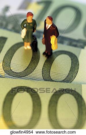 Toy businessman and businesswoman standing on top of Euro one hundred bank notes, close-up View Large Photo Image Picture - Toy businessman and businesswoman standing on top of Euro one hundred bank notes, close-up. Fotosearch