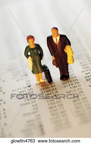 Toy businessman and businesswoman standing on top of paper with financial figures View Large Photo Image Stock Image - Toy businessman and businesswoman standing on top of paper with financial figures. Fotosearch