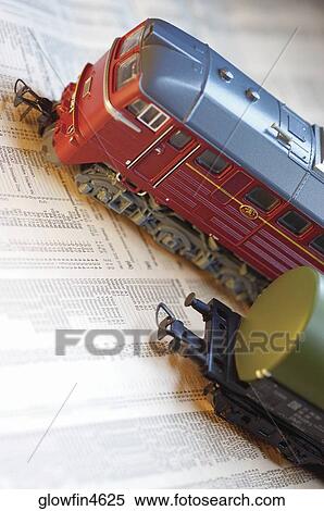 Toy train on top of stock report, close-up View Large Photo Image Stock Photography - Toy train on top of stock report, close-up. Fotosearch