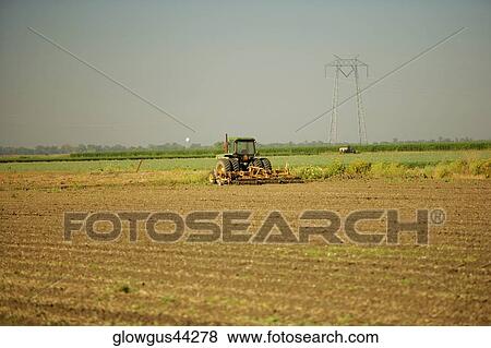 Tractor plowing a farm View Large Photo Image Stock Photo - Tractor plowing a farm. Fotosearch
