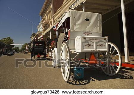 Two horse carts parked in front of a building View Large Photo Image Stock Photograph - Two horse carts parked in front of a building. Fotosearch