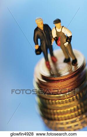 Two toy men on top of stack of coins, close-up View Large Photo Image Stock Photo - Two toy men on top of stack of coins, close-up. Fotosearch