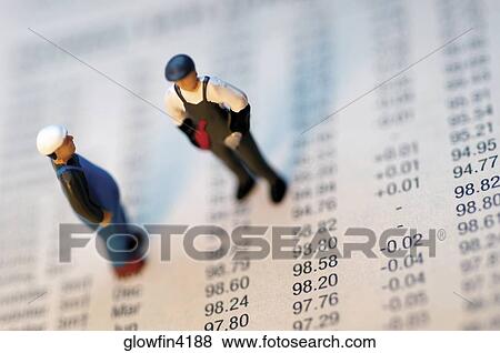 Two toy men standing on top of stock market report View Large Photo Image Stock Photo - Two toy men standing on top of stock market report. Fotosearch