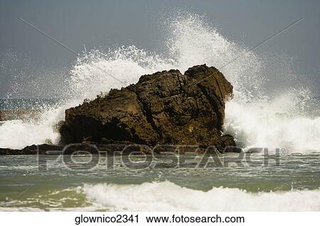 Waves crashing against a rock formation in the sea View Large Photo Image Stock Image - Waves crashing against a rock formation in the sea. Fotosearch
