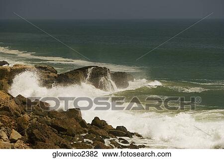 Waves crashing against a rock formation in the sea View Large Photo Image Stock Image - Waves crashing against a rock formation in the sea. Fotosearch