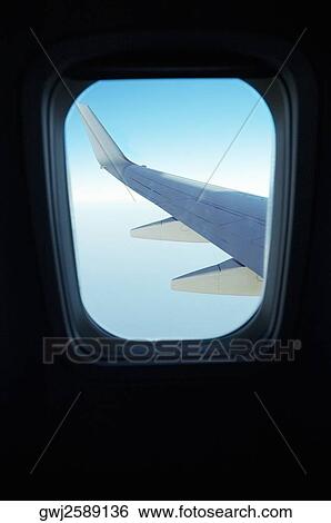 Airplane wing seen through an airplane window View Large Photo Image Stock Photograph - Airplane wing seen through an airplane window. Fotosearch