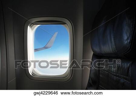 Airplane wing seen through an airplane window View Large Photo Image Stock Photograph - Airplane wing seen through an airplane window. Fotosearch