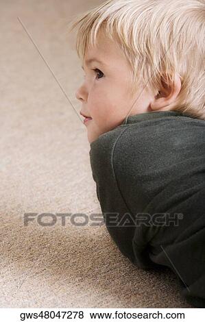 Boy lying down on the floor View Large Photo Image Stock Photo - Boy lying down on the floor. Fotosearch