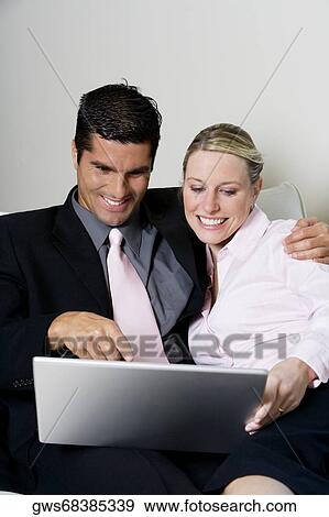 Businessman and a businesswoman using a laptop View Large Photo Image Stock Photo - Businessman and a businesswoman using a laptop. Fotosearch