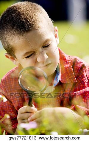 Close-up of a boy holding a magnifying glass View Large Photo Image Stock Image - Close-up of a boy holding a magnifying glass. Fotosearch