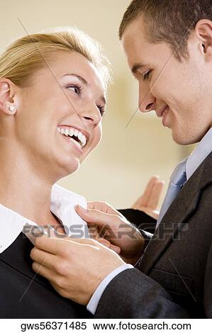 Close-up of a businessman adjusting a businesswoman's collar View Large Photo Image Stock Photography - Close-up of a businessman adjusting a businesswoman's collar. Fotosearch