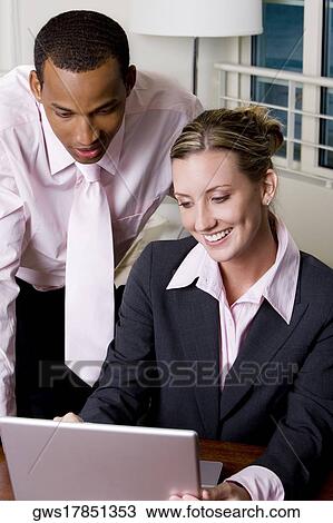 Close-up of a businessman and a businesswoman using a laptop View Large Photo Image Stock Image - Close-up of a businessman and a businesswoman using a laptop. Fotosearch