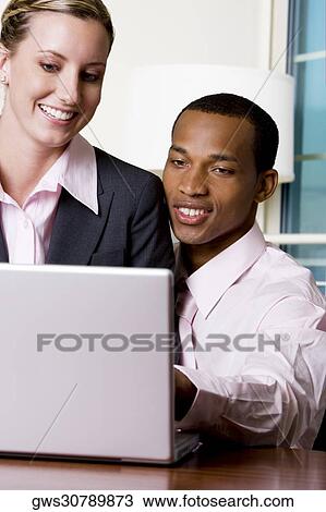 Close-up of a businessman and a businesswoman using a laptop View Large Photo Image Stock Image - Close-up of a businessman and a businesswoman using a laptop. Fotosearch