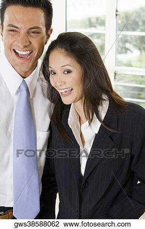 Stock Image - Close-up of a businessman and a businesswoman laughing. Fotosearch