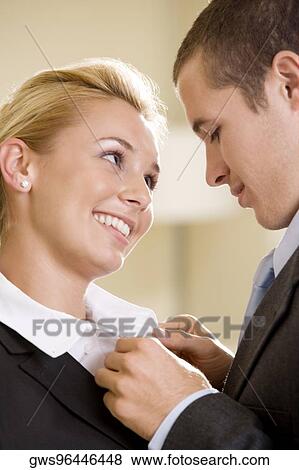 Close-up of a businessman buttoning a businesswoman's shirt View Large Photo Image Stock Photo - Close-up of a businessman buttoning a businesswoman's shirt. Fotosearch
