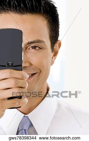Picture - Close-up of a businessman holding a mobile phone. Fotosearch