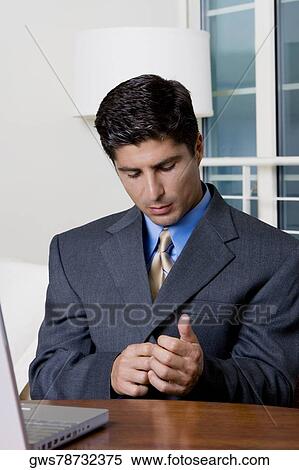 Close-up of a businessman sitting in front of a laptop View Large Photo Image Stock Photography - Close-up of a businessman sitting in front of a laptop. Fotosearch