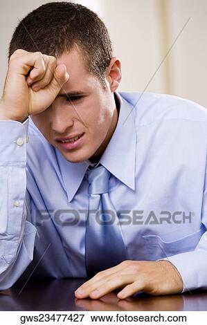 Close-up of a businessman sitting with his hand on his forehead View Large Photo Image Stock Photo - Close-up of a businessman sitting with his hand on his forehead. Fotosearch