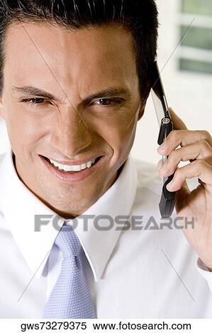 Close-up of a businessman talking on a mobile phone View Large Photo Image Stock Photography - Close-up of a businessman talking on a mobile phone. Fotosearch