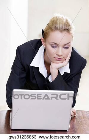 Stock Image - Close-up of a businesswoman in front of a laptop. Fotosearch