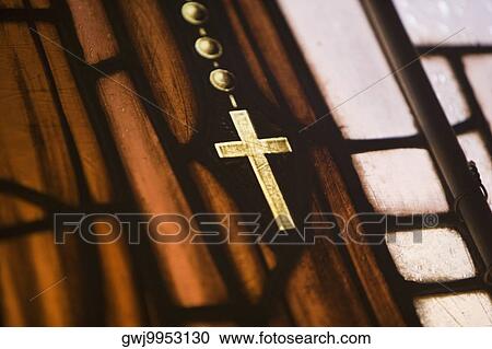 Stock Image - Close-up of a cross on a stained glass window. Fotosearch